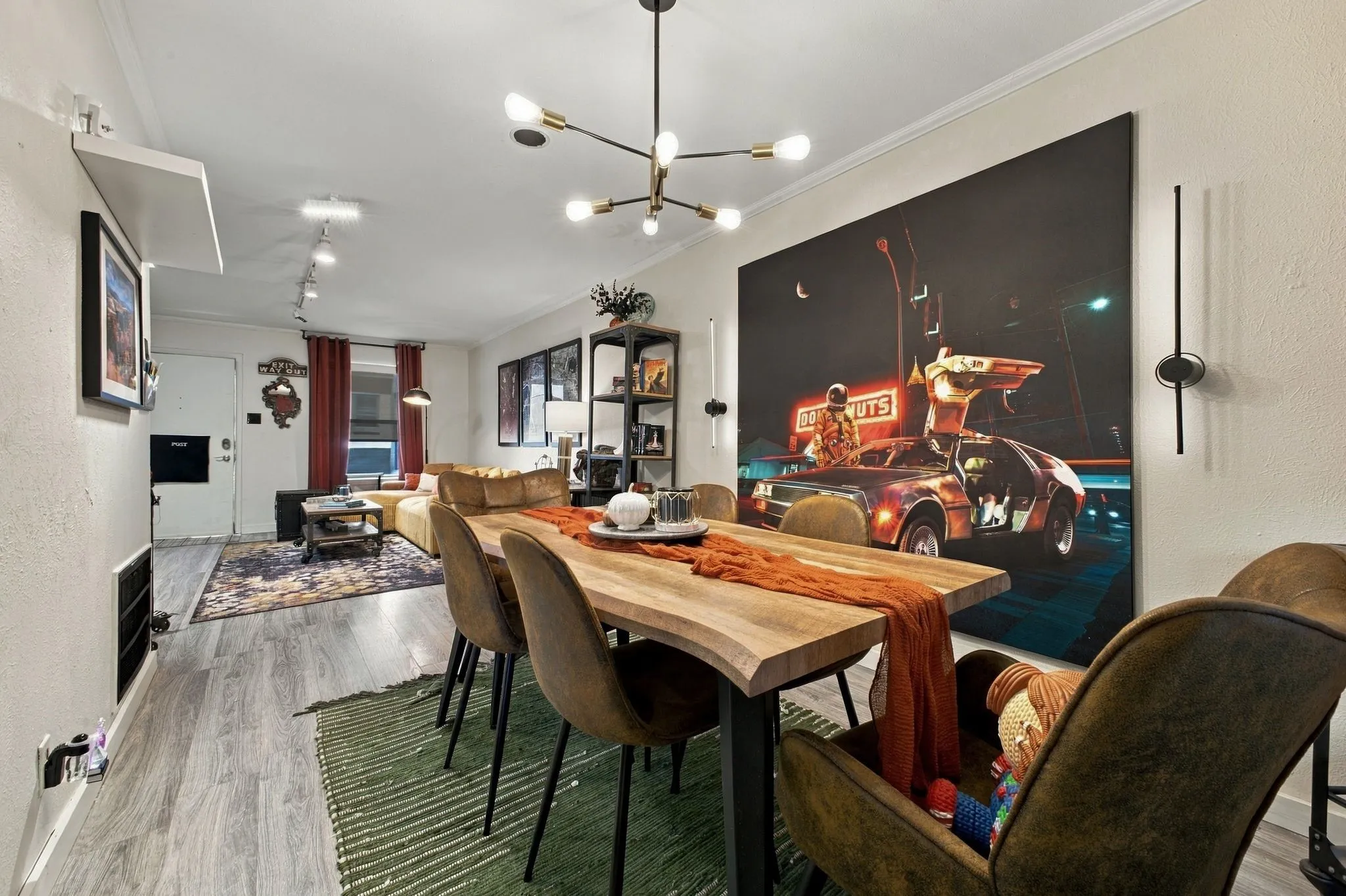 Multi-light sputnik chandelier, wood-finish flooring, adjustable track lighting, and vertical wall-mounted accent fixtures