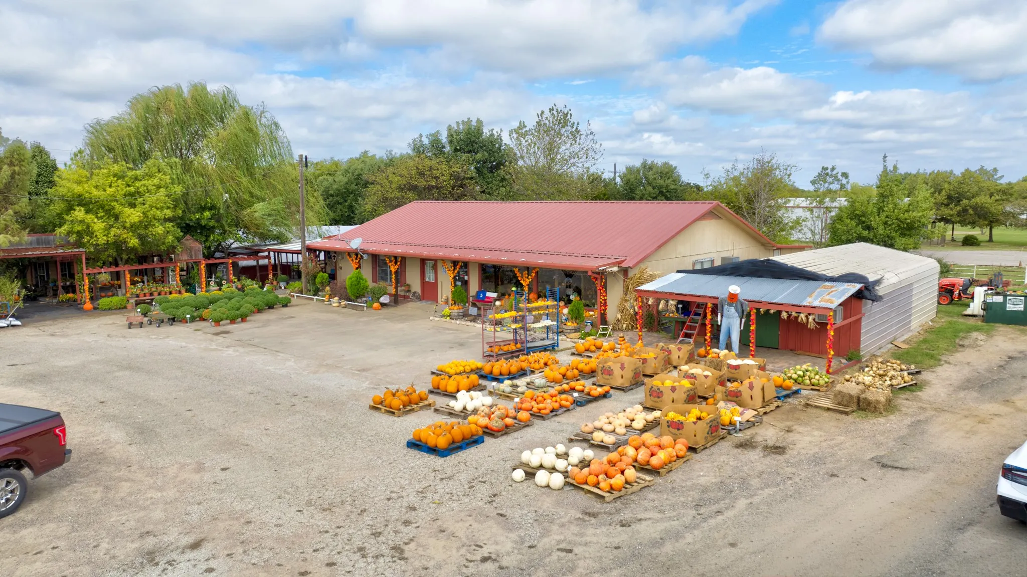 Commercial property featuring a sprawling gravel lot, a single-story structure with a metal roof, and covered exterior display areas