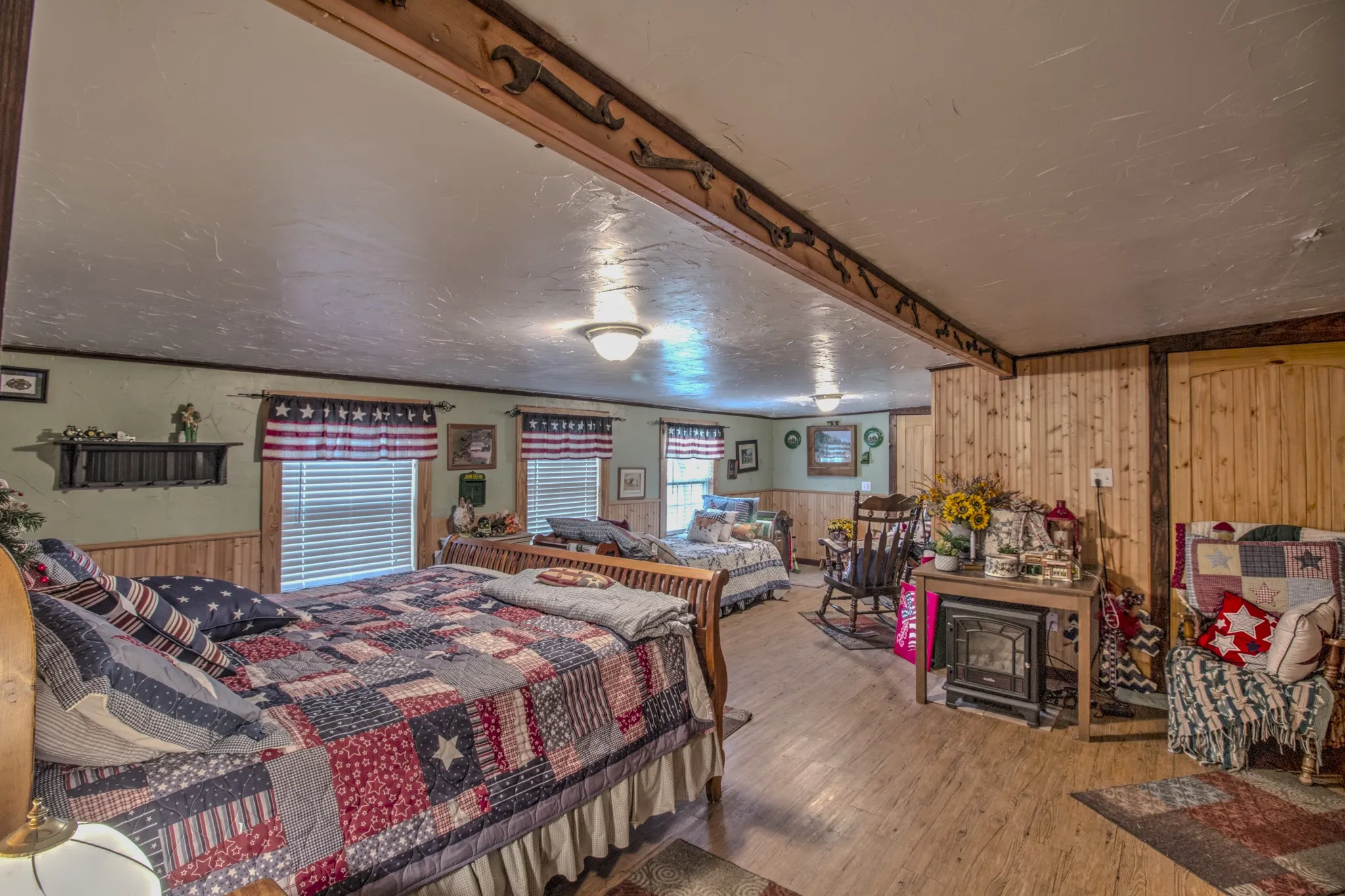 Textured ceilings with wood-beam detailing, wood-finish flooring, and natural wood wall paneling