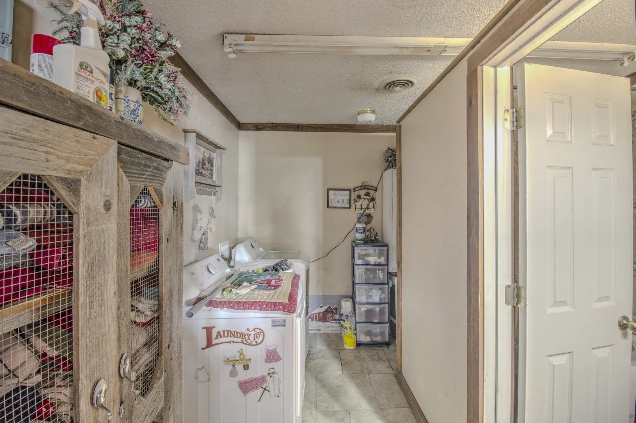 Built-in wooden cabinetry featuring wire mesh door panels, six-panel interior door, and tile flooring