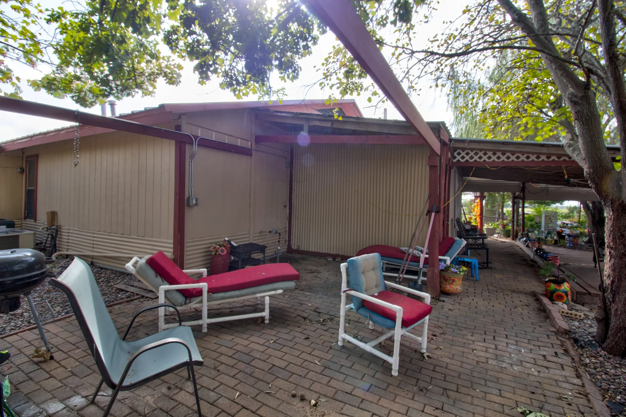 Exterior patio featuring brick pavers, a structural beam support system, and a covered porch area