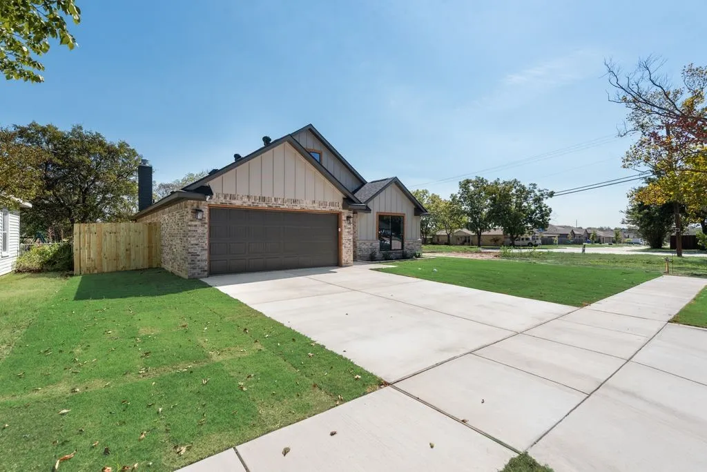 Single-story residence featuring a brick and vertical-siding exterior, a two-car garage, and a concrete driveway