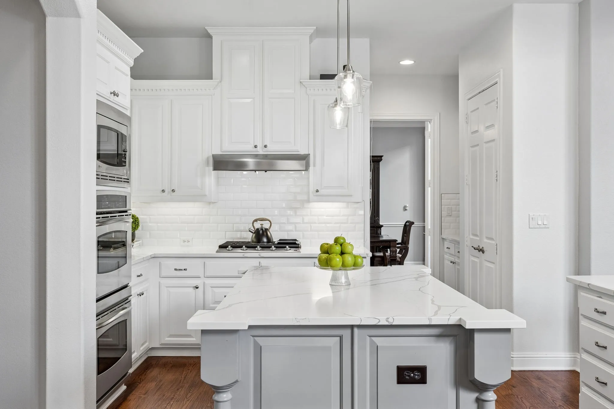 Bright, updated kitchen featuring quartz countertops, crisp white cabinetry, stainless steel
appliances, and a spacious island ideal for
gathering.