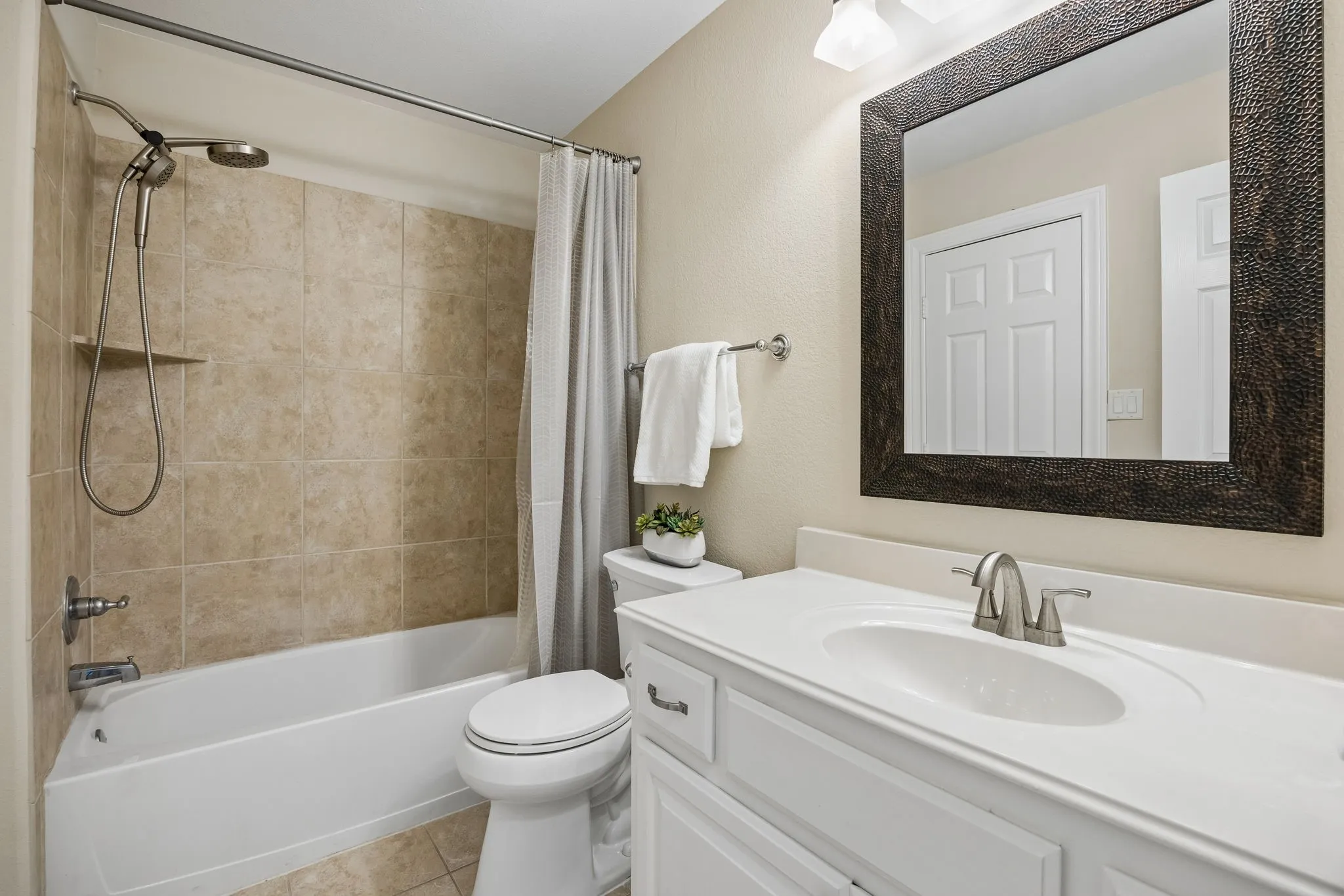 Well-appointed hall bath conveniently serving a
secondary bedroom, media room, and game room,with neutral finishes and tiled shower surround.