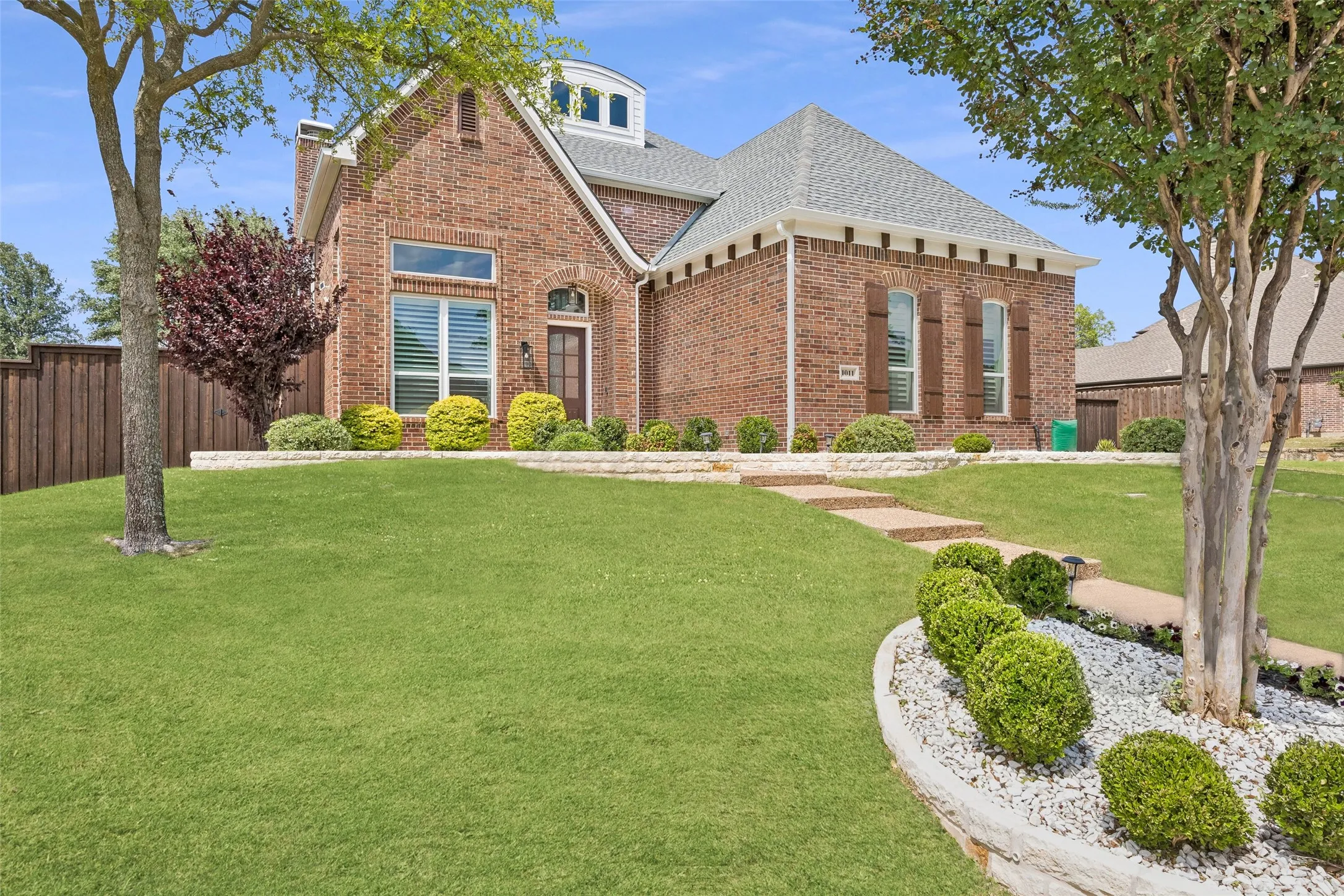 Timeless brick elevation with mature landscaping
and inviting curb appeal.
