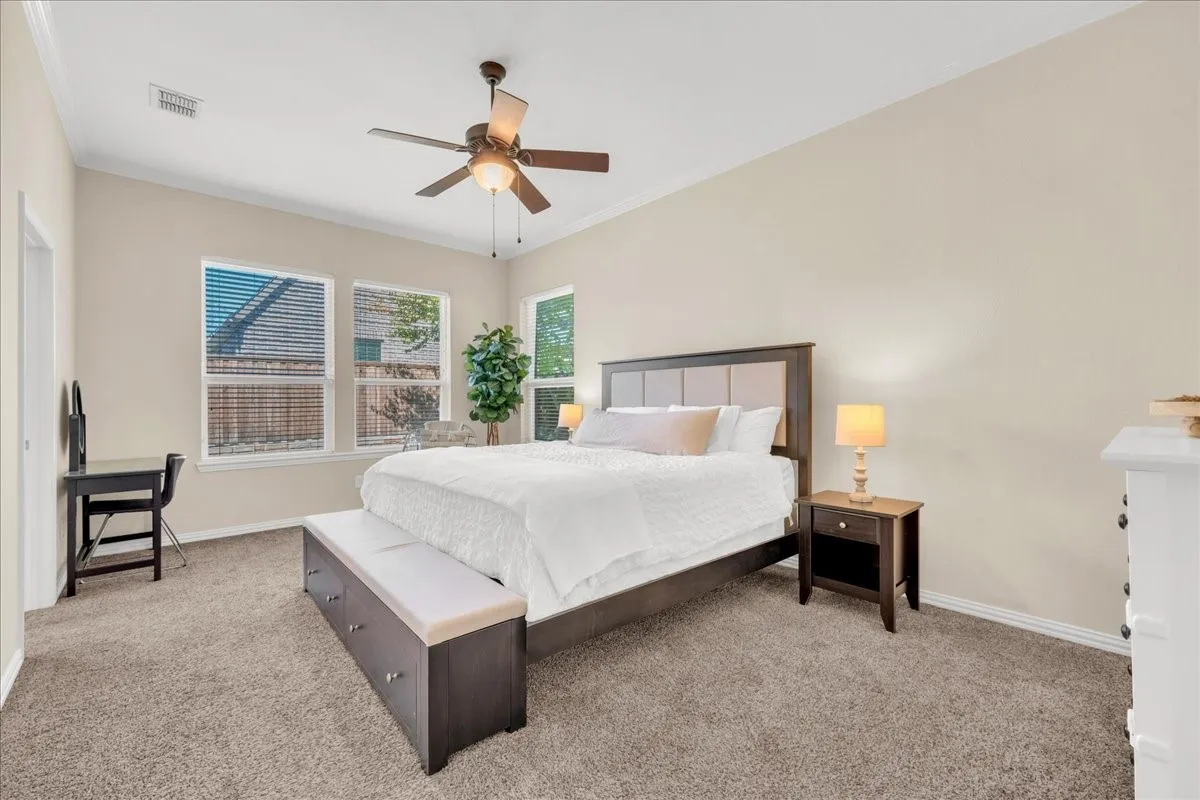 Spacious bedroom with vaulted ceiling, ceiling fan, and carpeted flooring