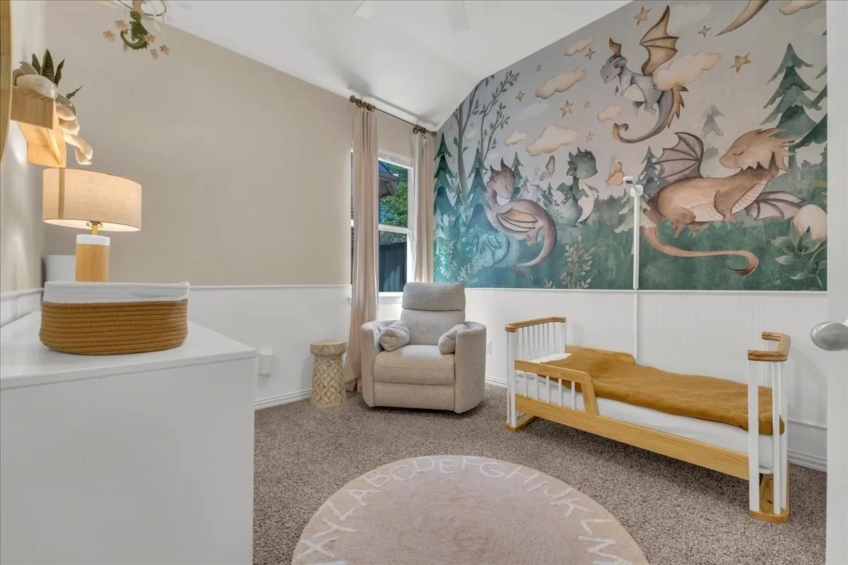 Vaulted ceiling, wainscoting, carpeted flooring, window with natural light, and ceiling fan