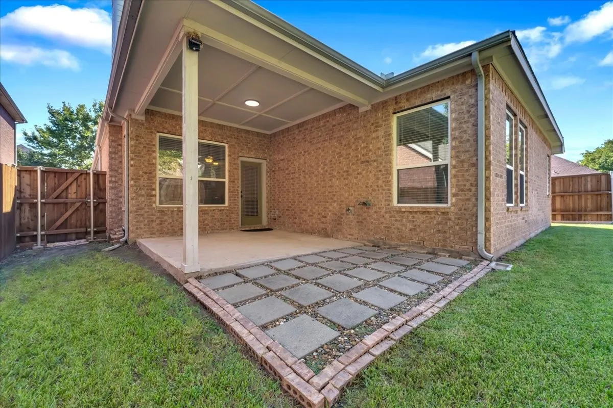 Covered patio with recessed lighting, brick exterior, and a paver stone extension