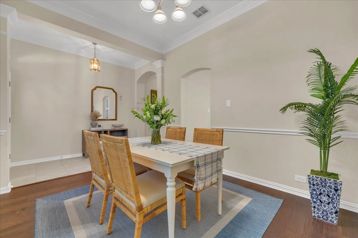 Wood-finish flooring, crown molding, and chair rail detailing