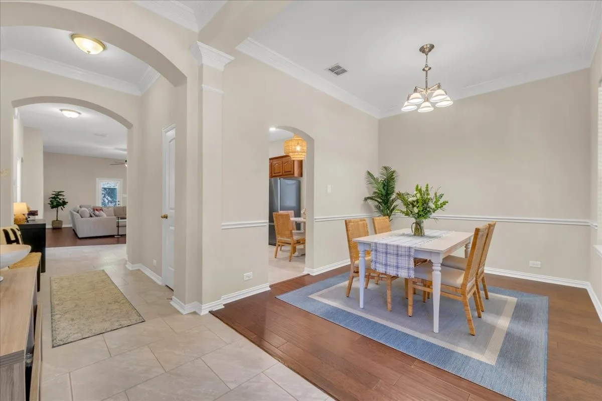 Archway entries, crown molding, chair rail detailing, wood-finish flooring, and recessed lighting