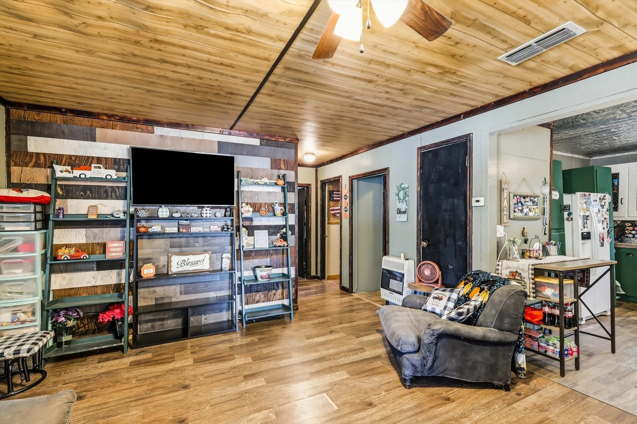 Wood-plank ceiling, multi-tonal wood-finish plank wall feature, and wood-finish flooring throughout