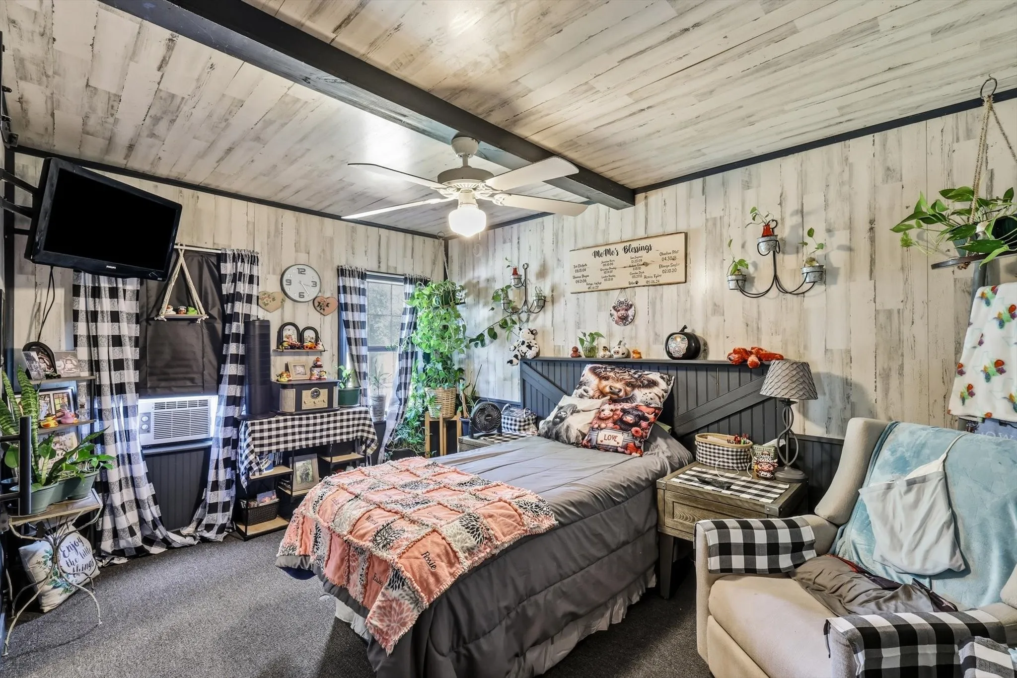 Interior room featuring white-wash plank-style ceiling and wall paneling, dark wood-tone exposed ceiling beam, and integrated dark-tone headboard with horizontal board-and-batten detailing