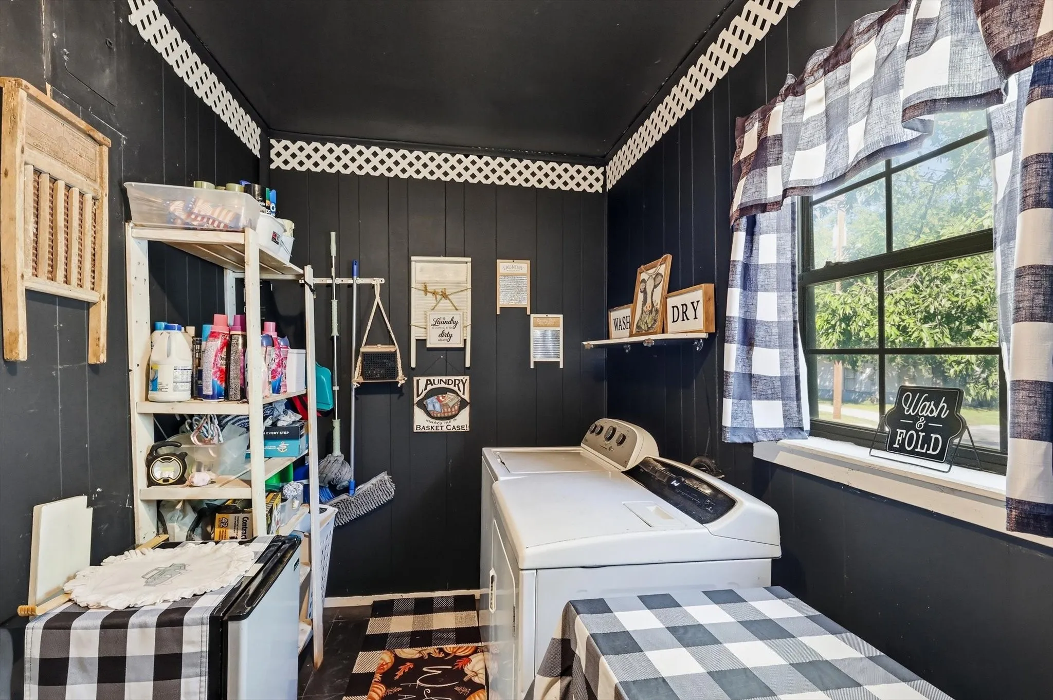 Vertical paneled walls with decorative lattice trim, window with natural lighting, and wall-mounted shelving