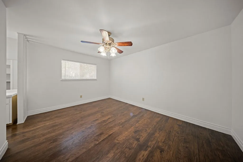 Backyard featuring a wood privacy fence, concrete patio area, mature trees, and vinyl siding exterior