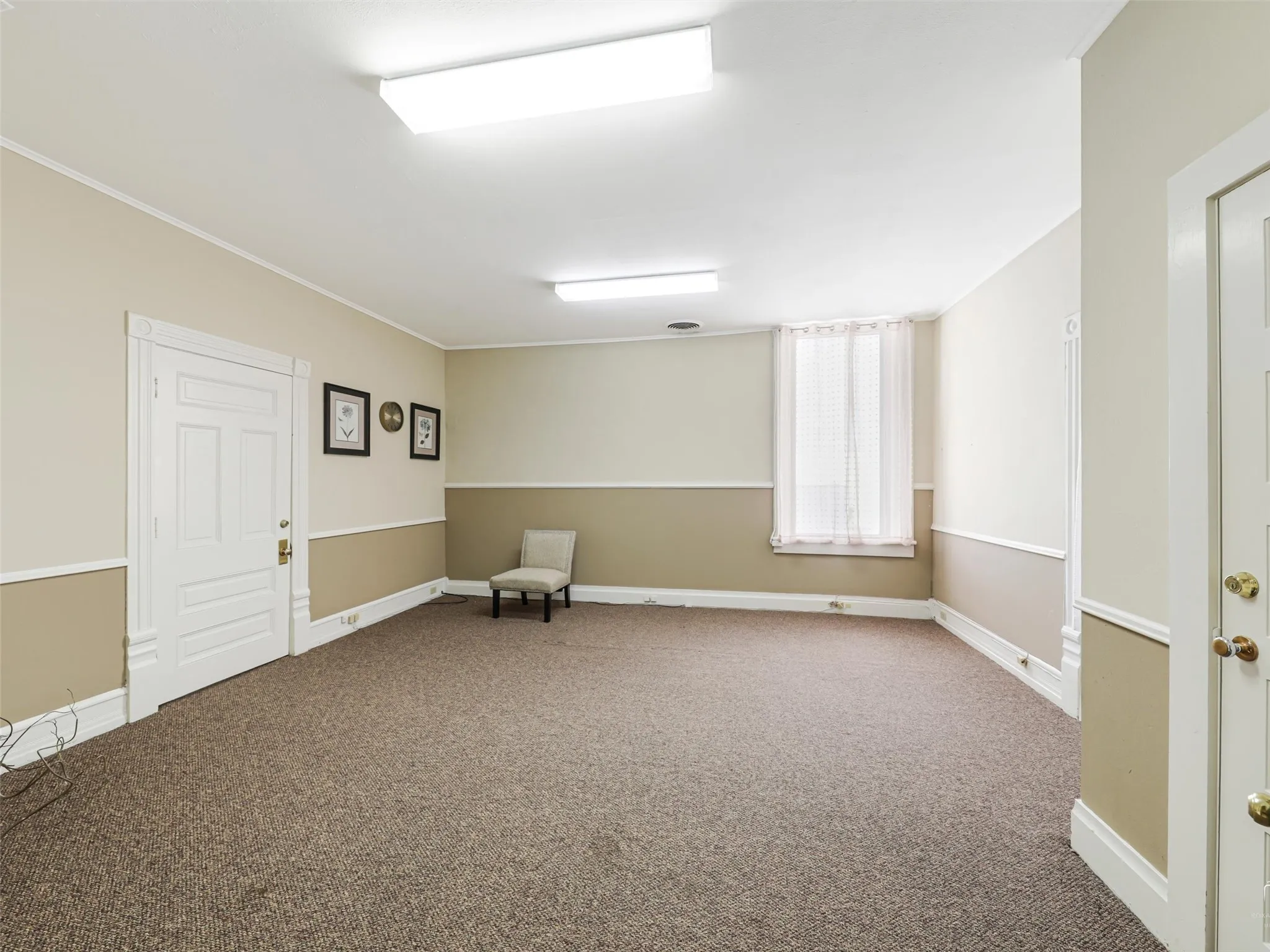 Neutral wall tones featuring chair rail molding, wall-to-wall carpeting, and two paneled interior doors