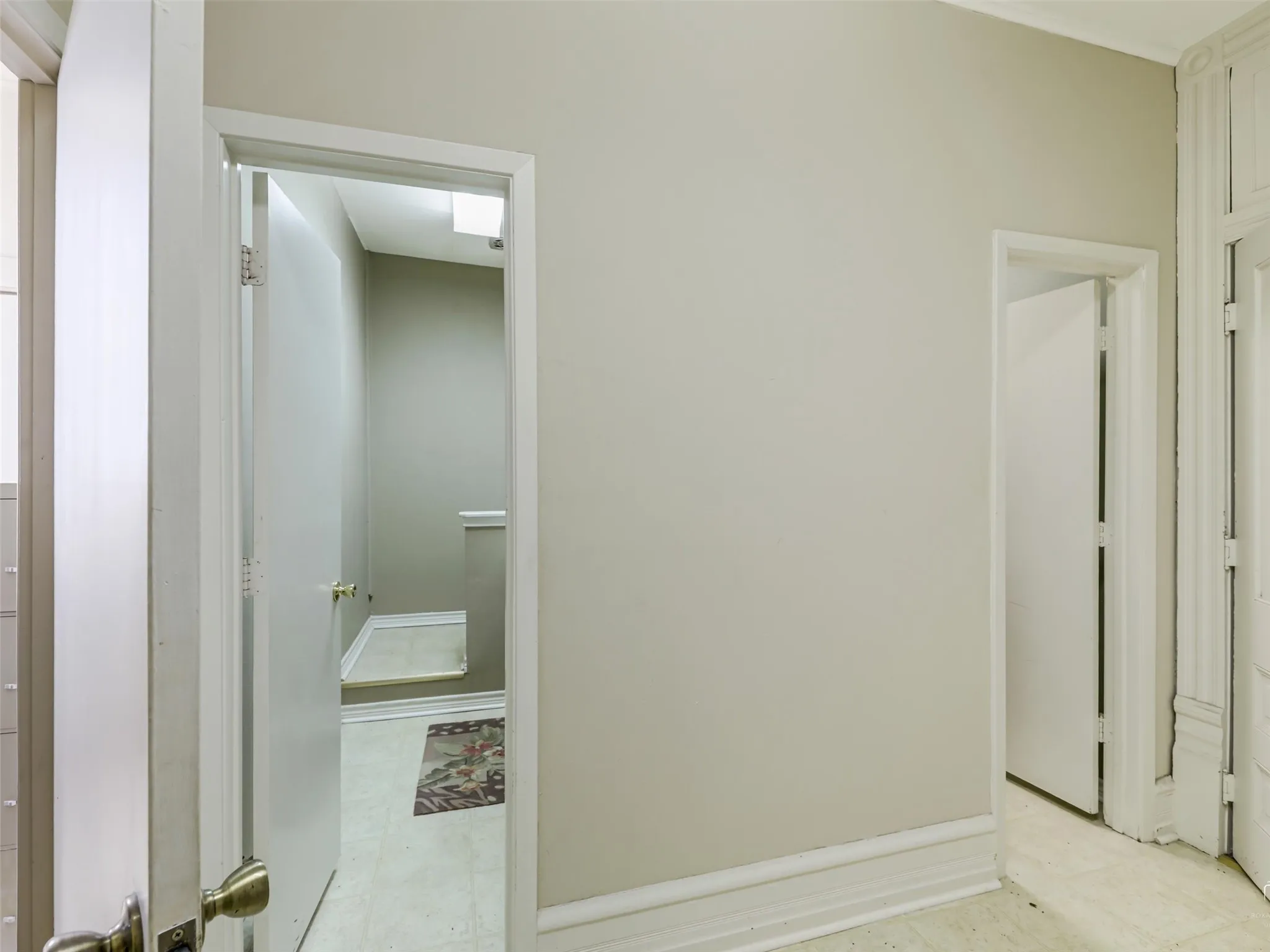 Neutral-toned interior walls featuring crisp white door casings and traditional architectural trim