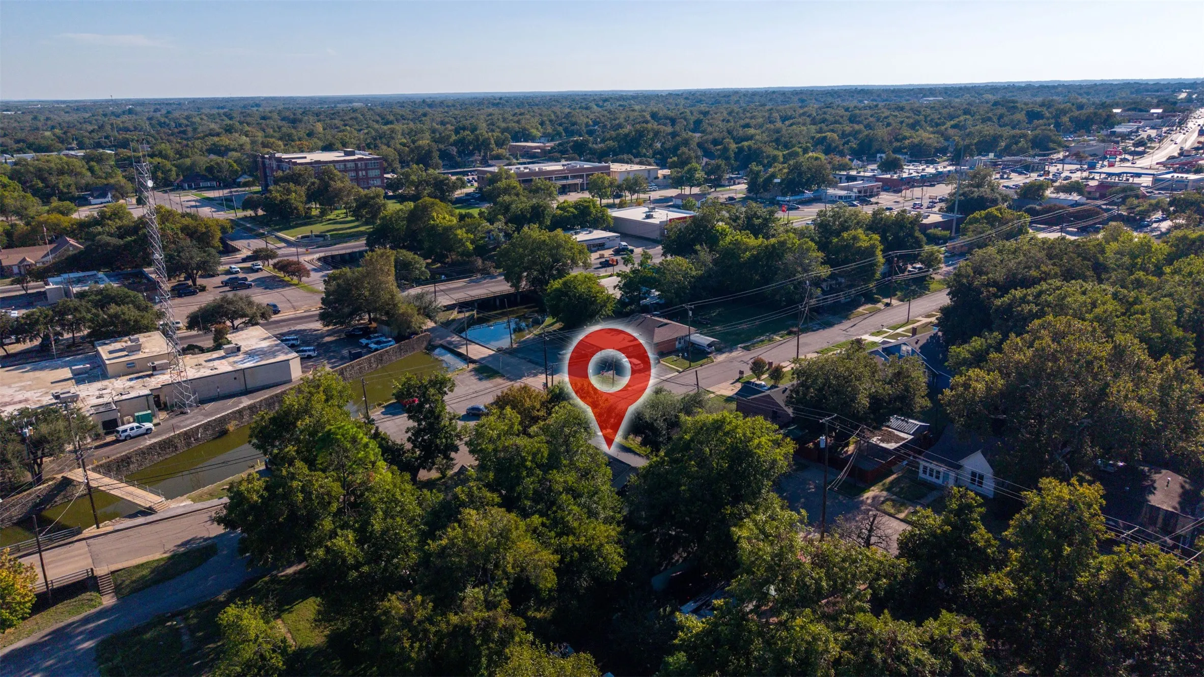 Aerial perspective of property featuring mature trees and proximity to local thoroughfares