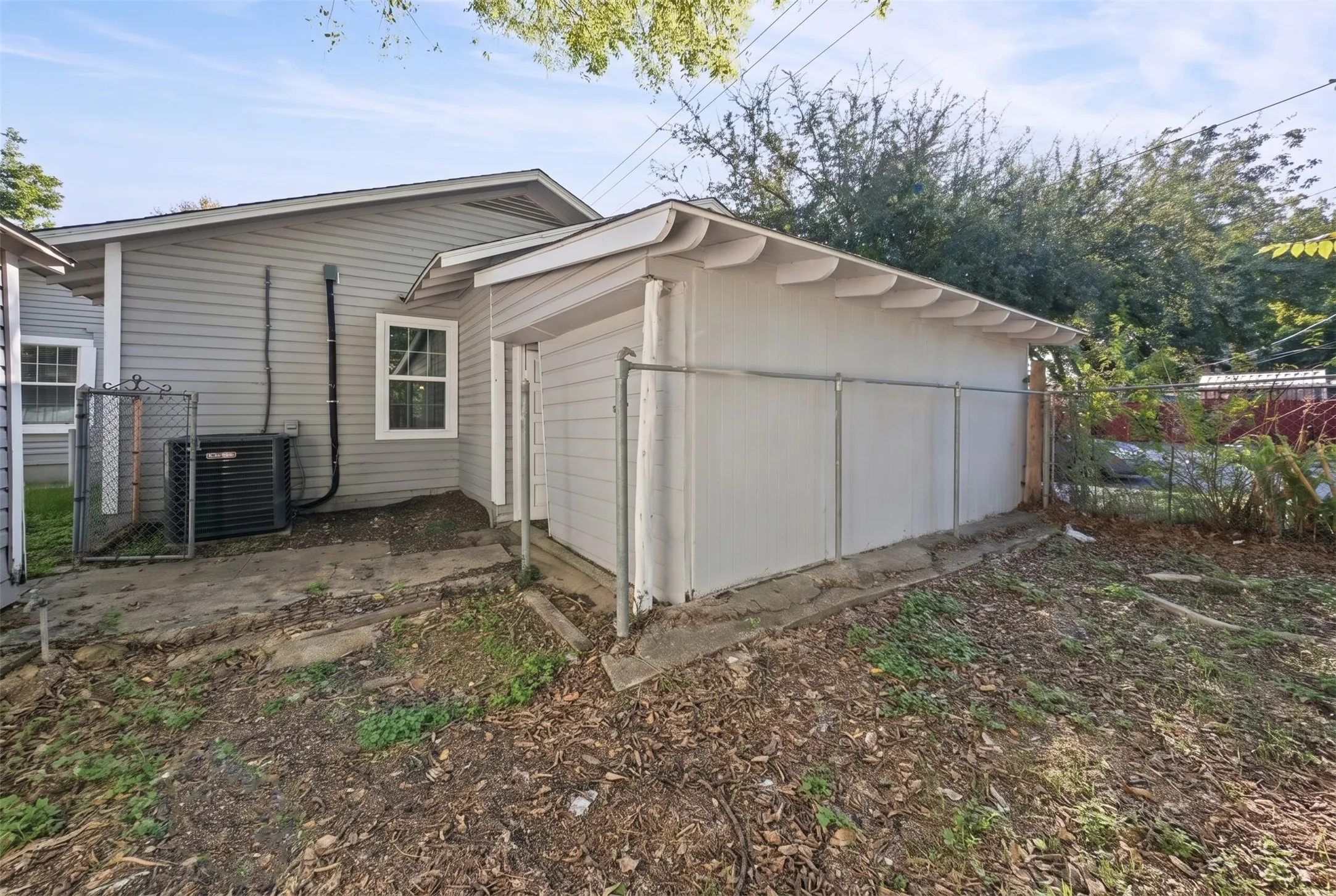 Enclosed porch featuring exposed wood beam ceiling, wood-paneled walls, a single-entry door, and concrete flooring