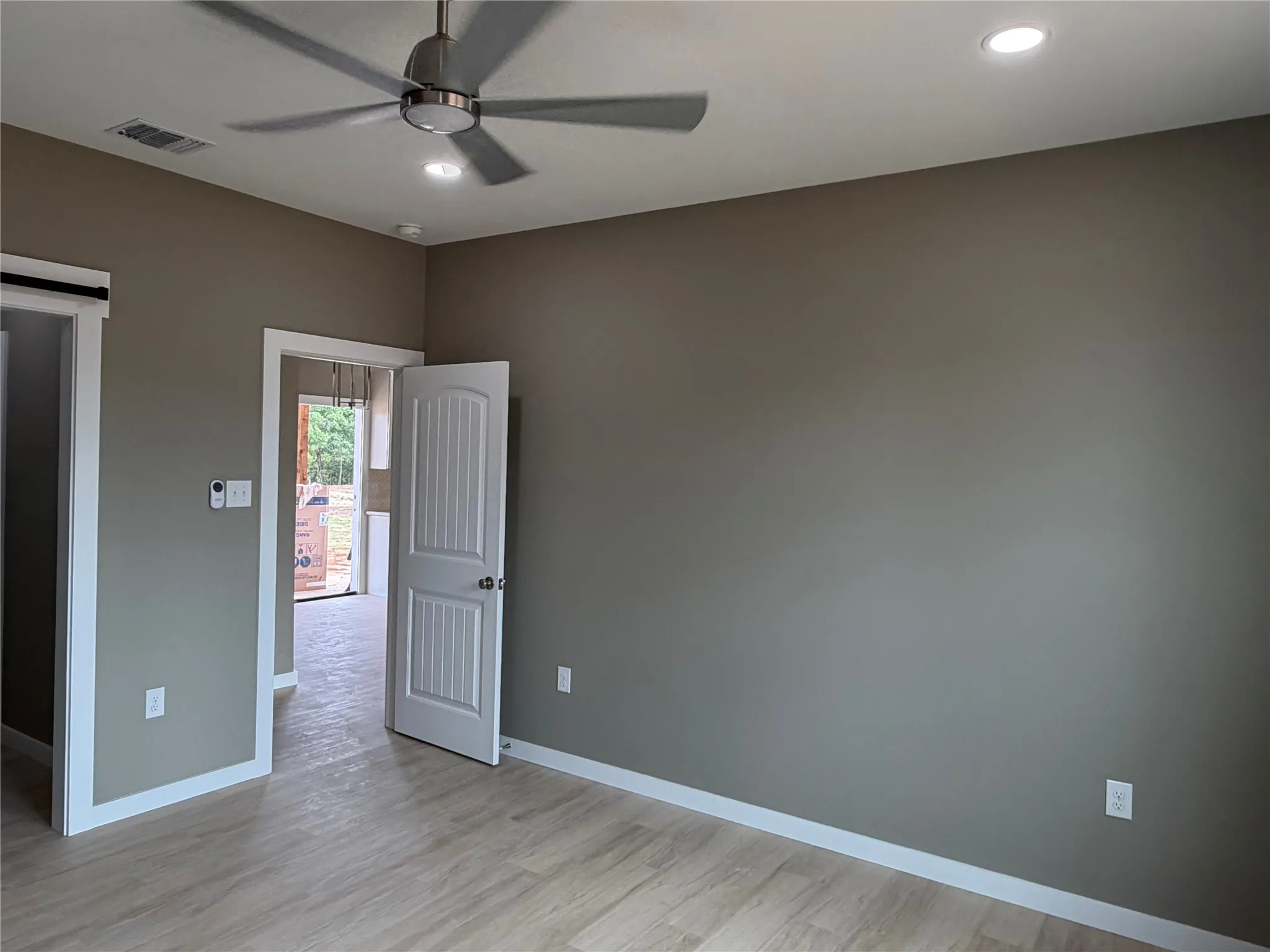 Primary Bedroom interior space featuring wood-finish flooring, a multi-blade ceiling fan, recessed lighting, and white paneled interior doors