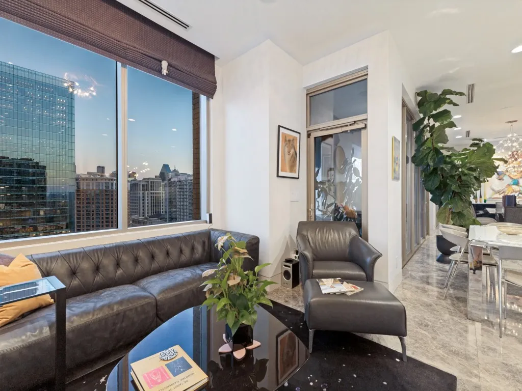 Expansive windows with cityscape, recessed lighting, and elegant hard surface flooring