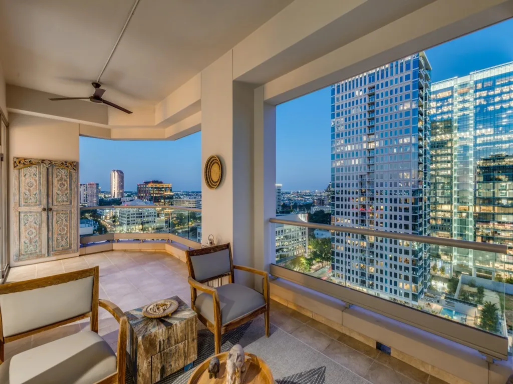 Tiled outdoor balcony with glass railing, providing expansive cityscape scenery