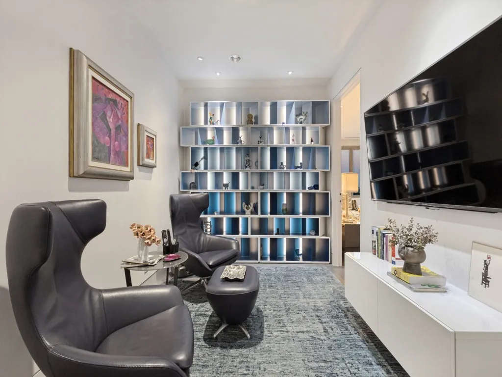 Recessed lighting, built-in shelving with integrated lighting, wall-mounted display, and a wall-mounted media console