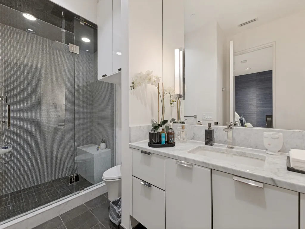 Vanity with a polished stone countertop, integrated rectangular sink, and chrome-finish fixtures