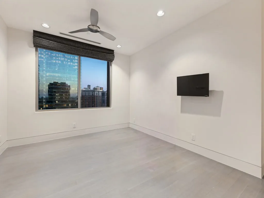 Interior room featuring wood-finish flooring, recessed lighting, a ceiling fan, and large windows with integrated window treatments