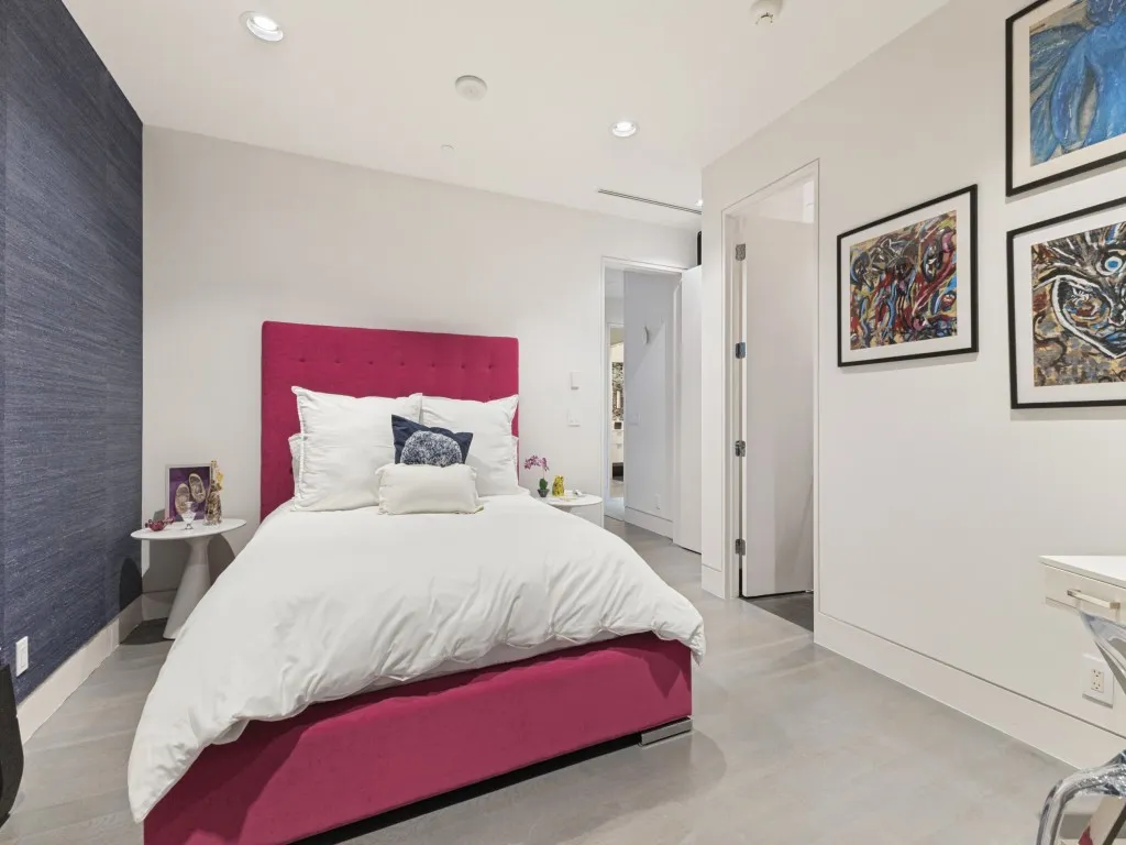 Textured navy accent wall, light-toned wood-finish flooring, and recessed ceiling lighting
