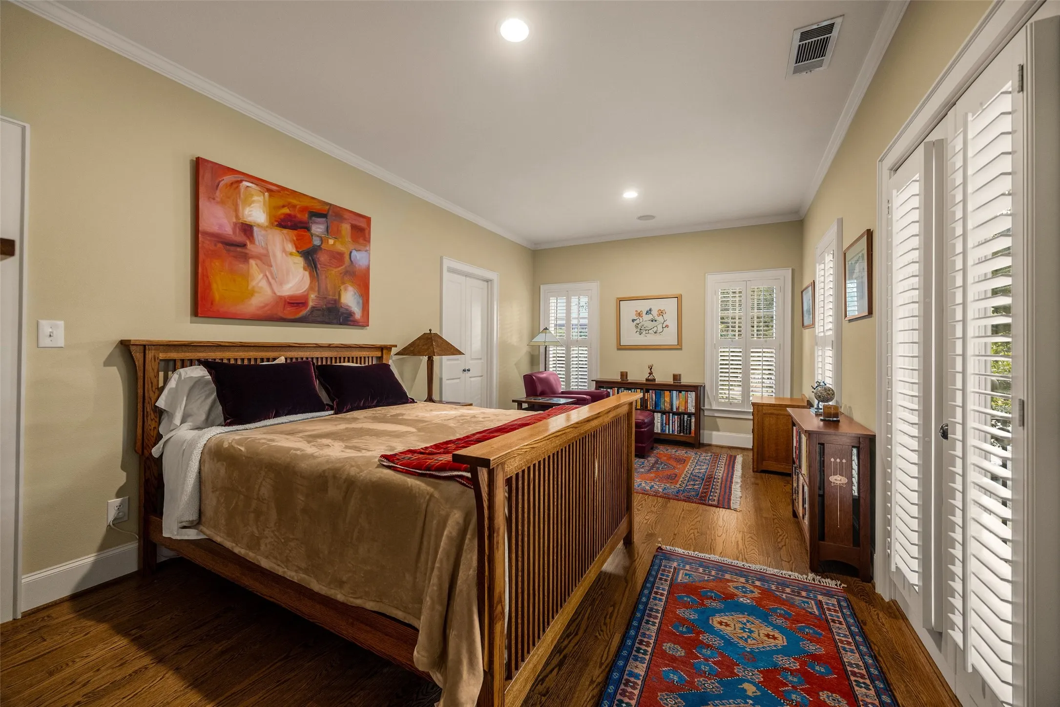 Room featuring wood-finish flooring, recessed lighting, and white plantation shutters on the windows and French doors