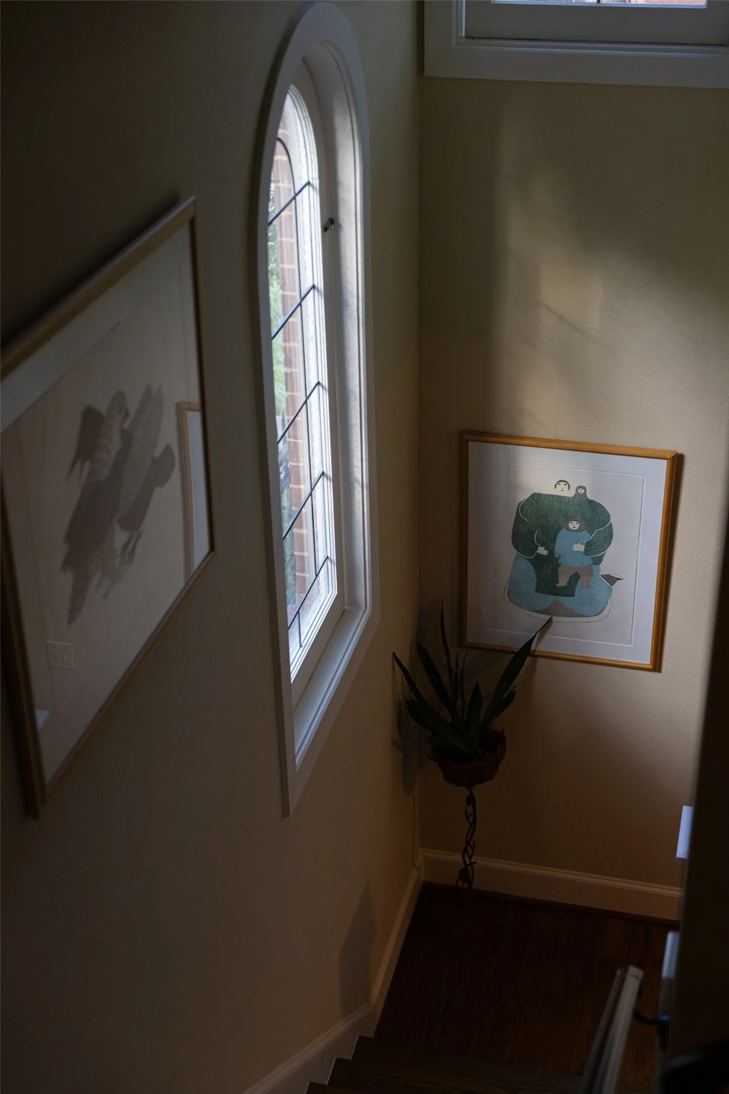 Arched window featuring leaded glass detailing and dark wood-finish flooring