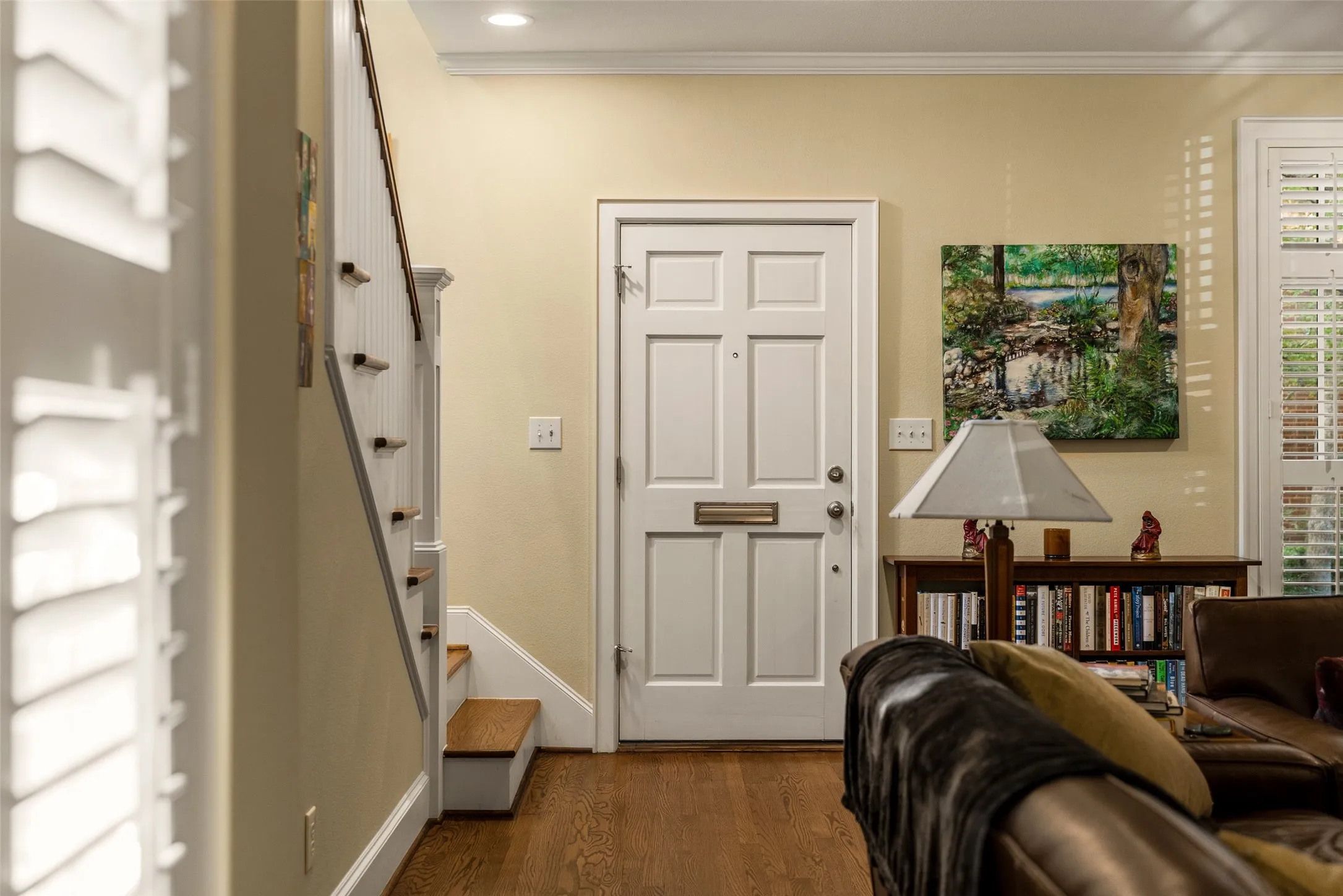 Entryway featuring a six-panel exterior door with integrated mail slot, wood-finish flooring, staircase with white-painted balusters and wood-finish treads, and recessed ceiling lighting