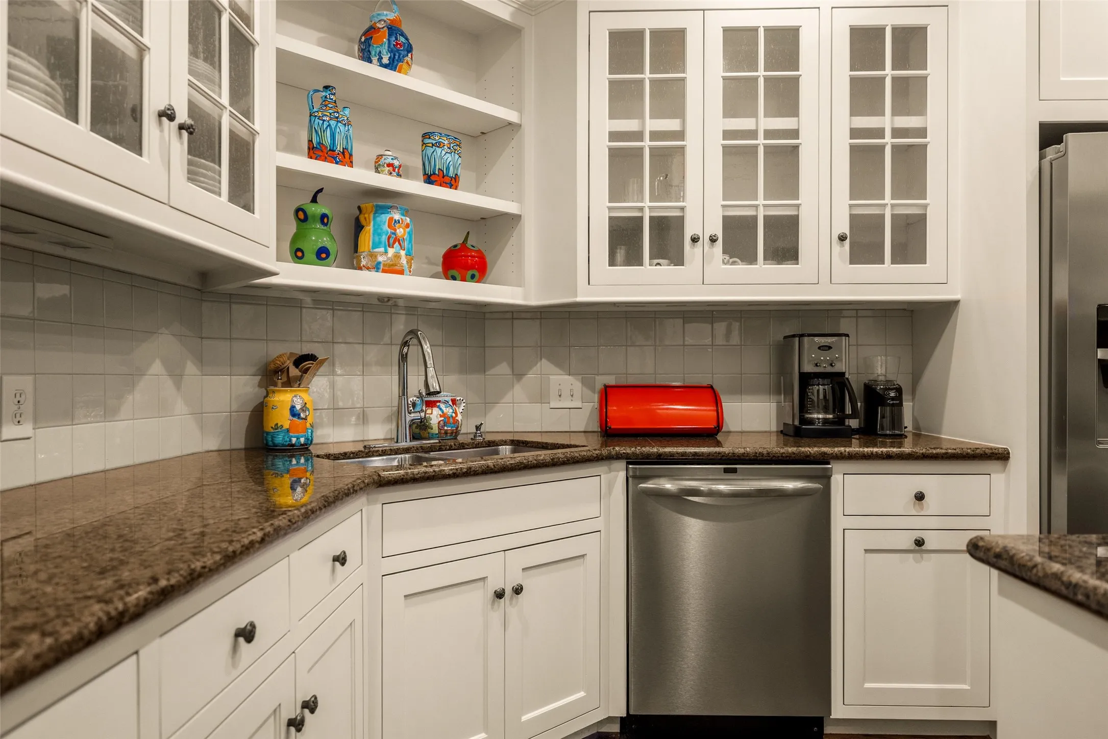 Kitchen featuring white cabinetry, glass-front upper cabinets, open shelving, stone-finish countertops, and stainless steel appliances