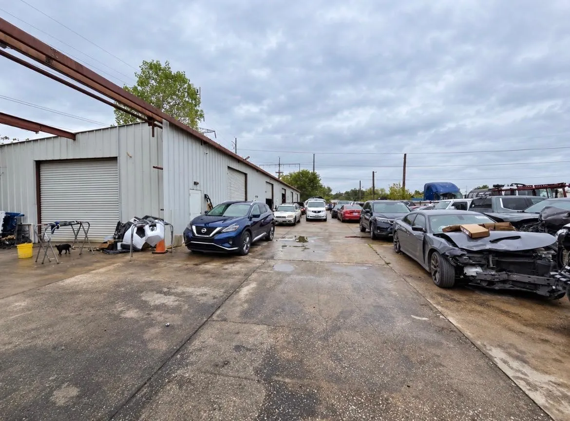 Industrial metal-sided building with multiple roll-up doors and a concrete exterior lot