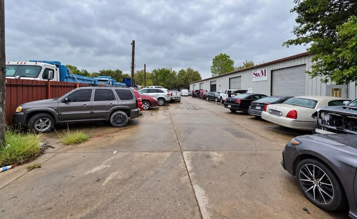 Industrial building featuring a concrete exterior, metal roll-up bay doors, and a paved lot