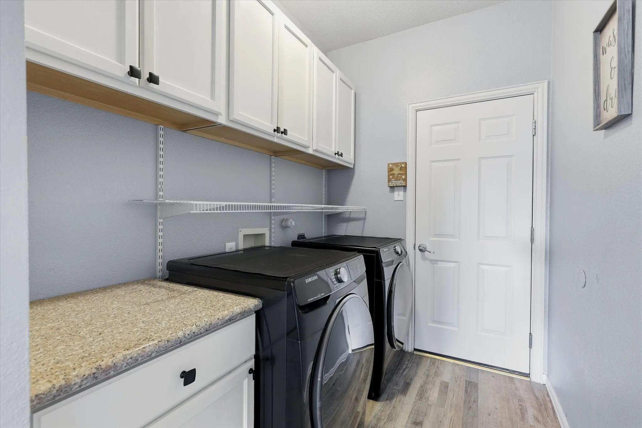 Upper cabinets, open shelving & a folding counter add practical storage to the laundry room.