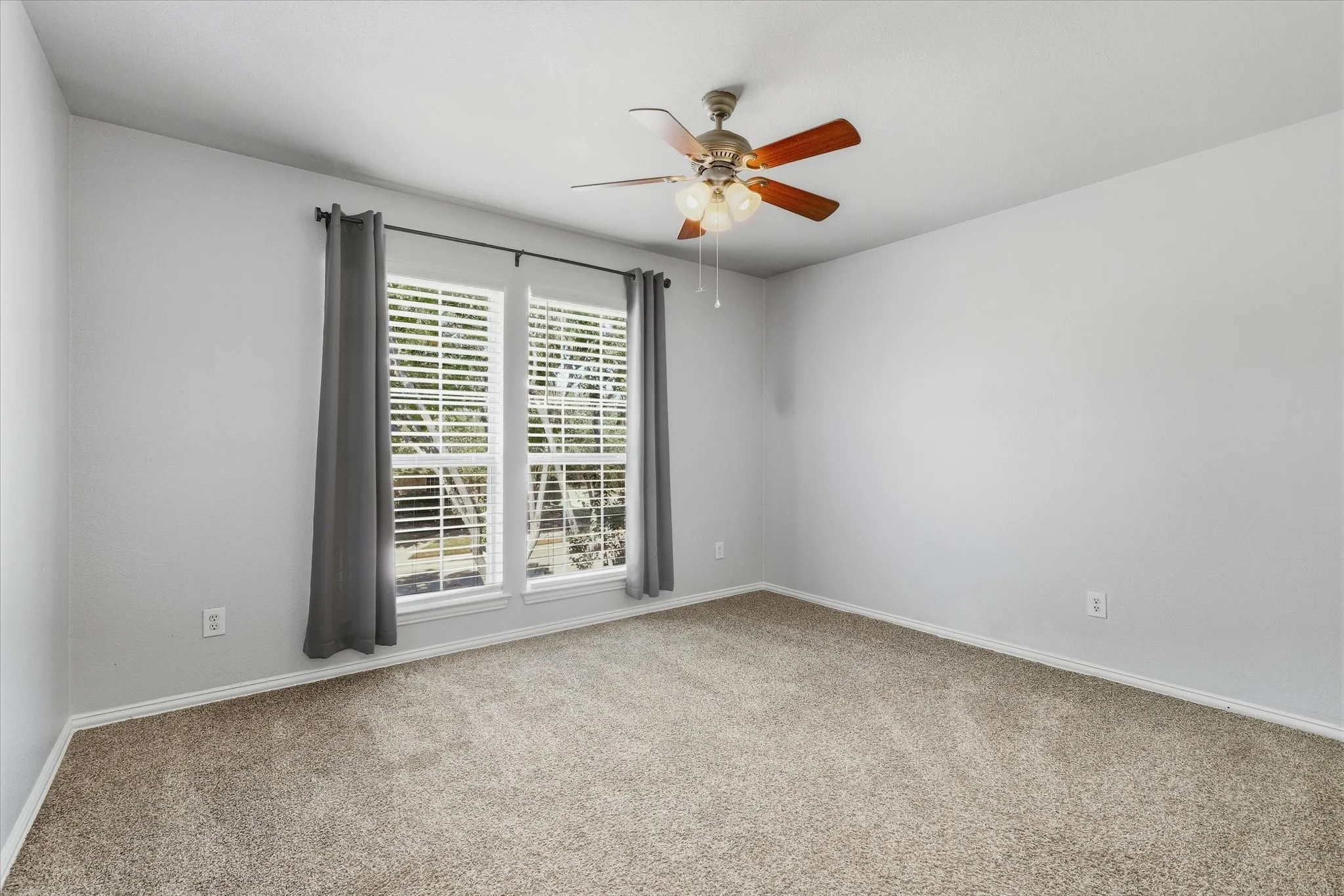 Tall windows brighten this additional upstairs bedroom, offering comfortable space for guests or everyday use.