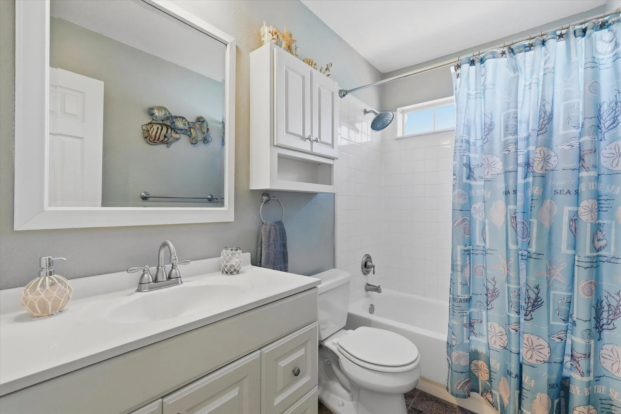 The upstairs full bath includes vanity storage & a tiled tub/shower combination.