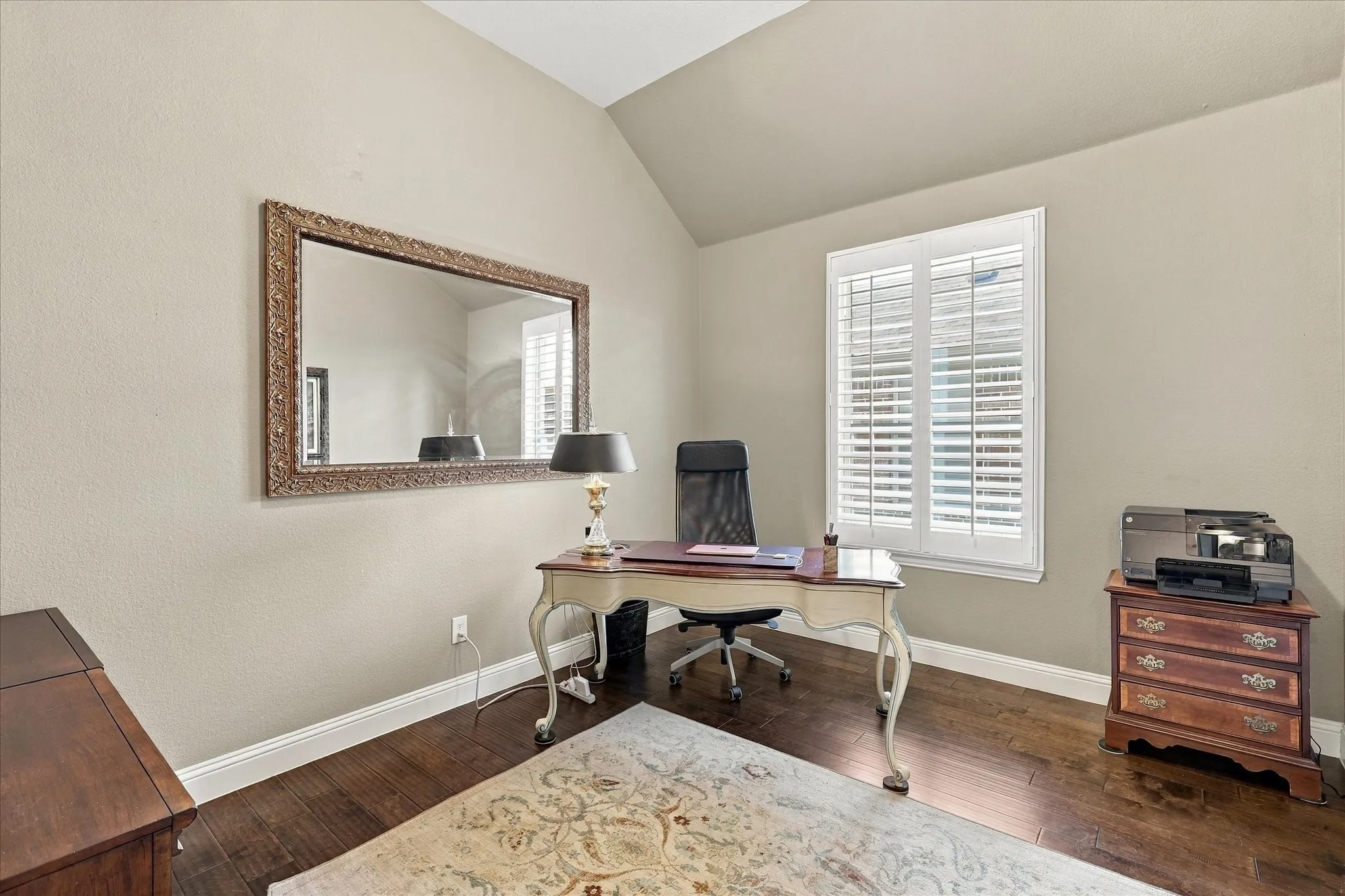 Vaulted ceiling, wood-finish flooring, and window shutters