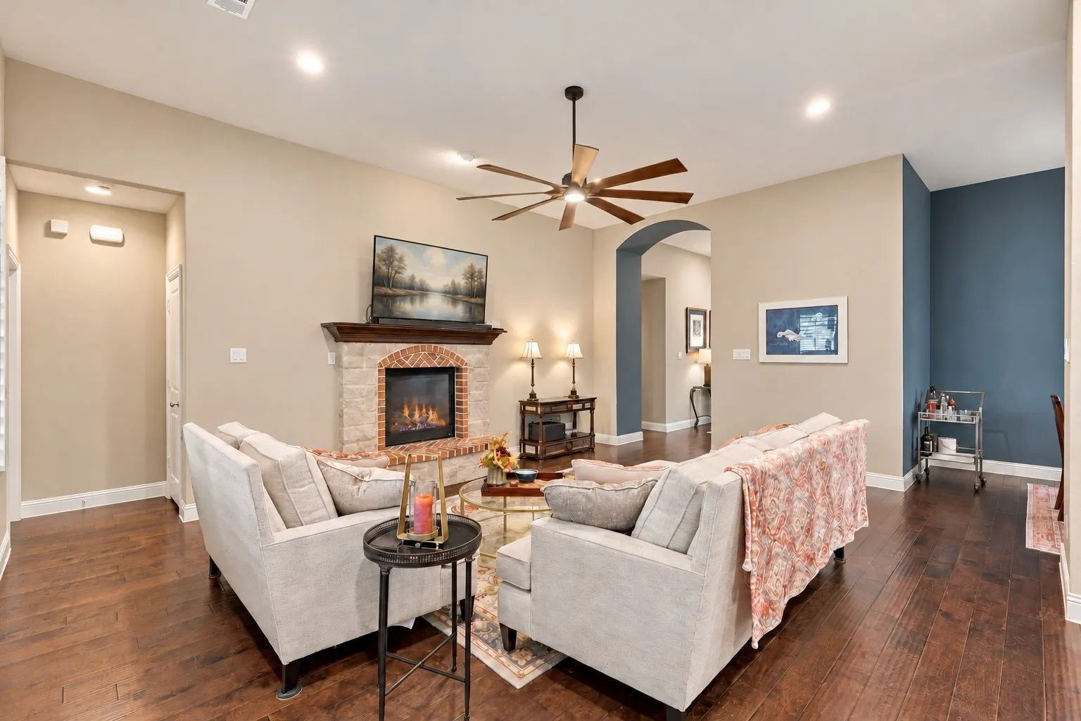 Living area featuring dark wood-finish flooring, recessed lighting, and a multi-blade ceiling fan