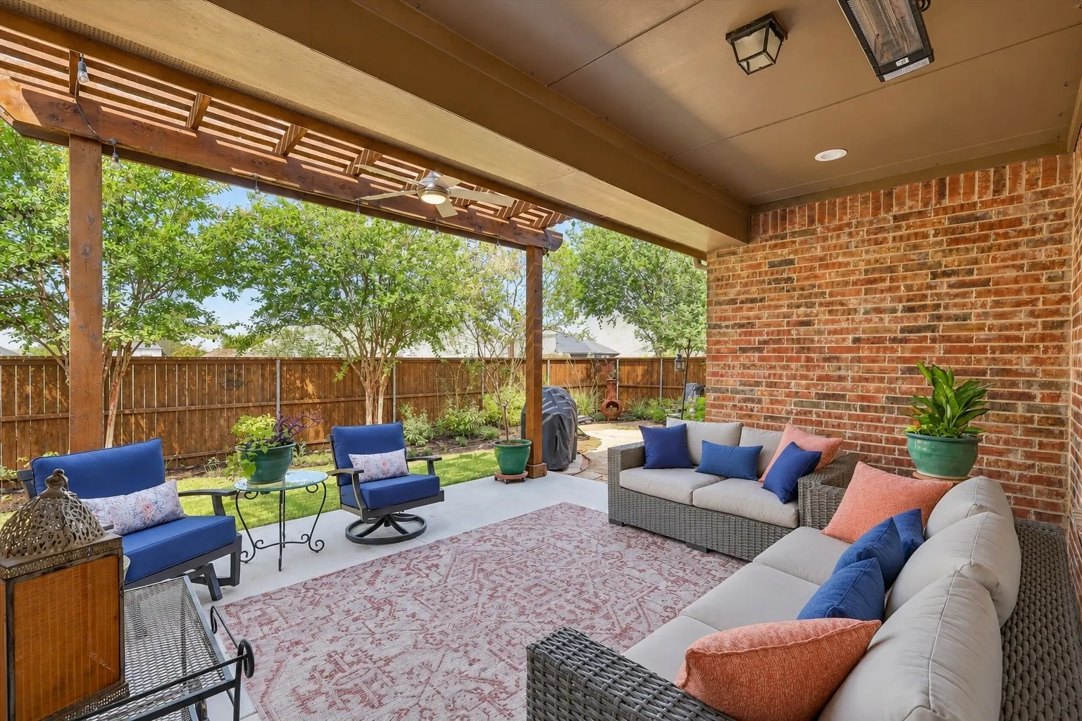 Gorgeous exterior covered back patio with extension, multiple flowerbeds, and serene landscaping.