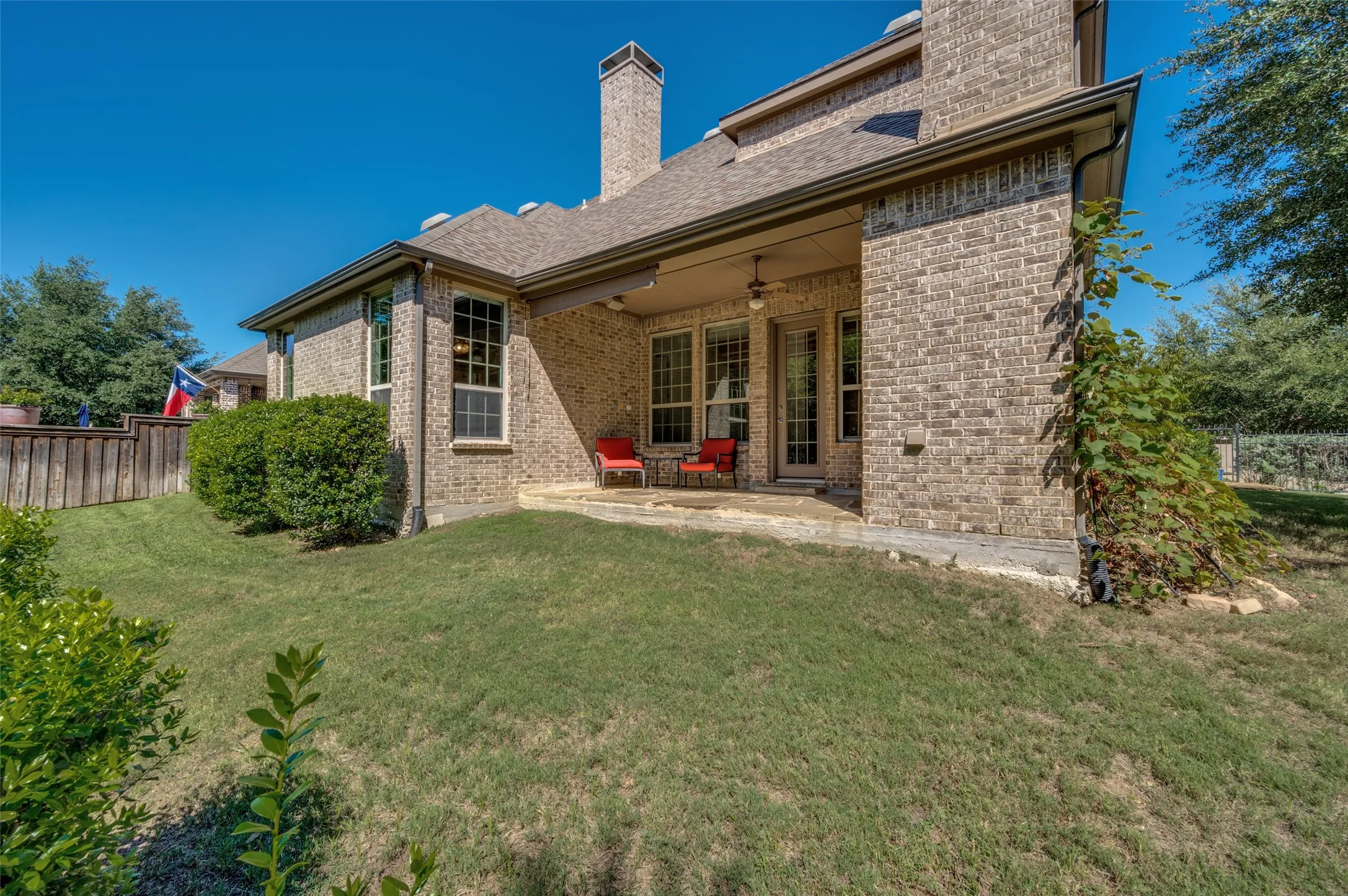 Covered patio with a wood burning fireplace overlooking the greenbelt and spacious backyard.