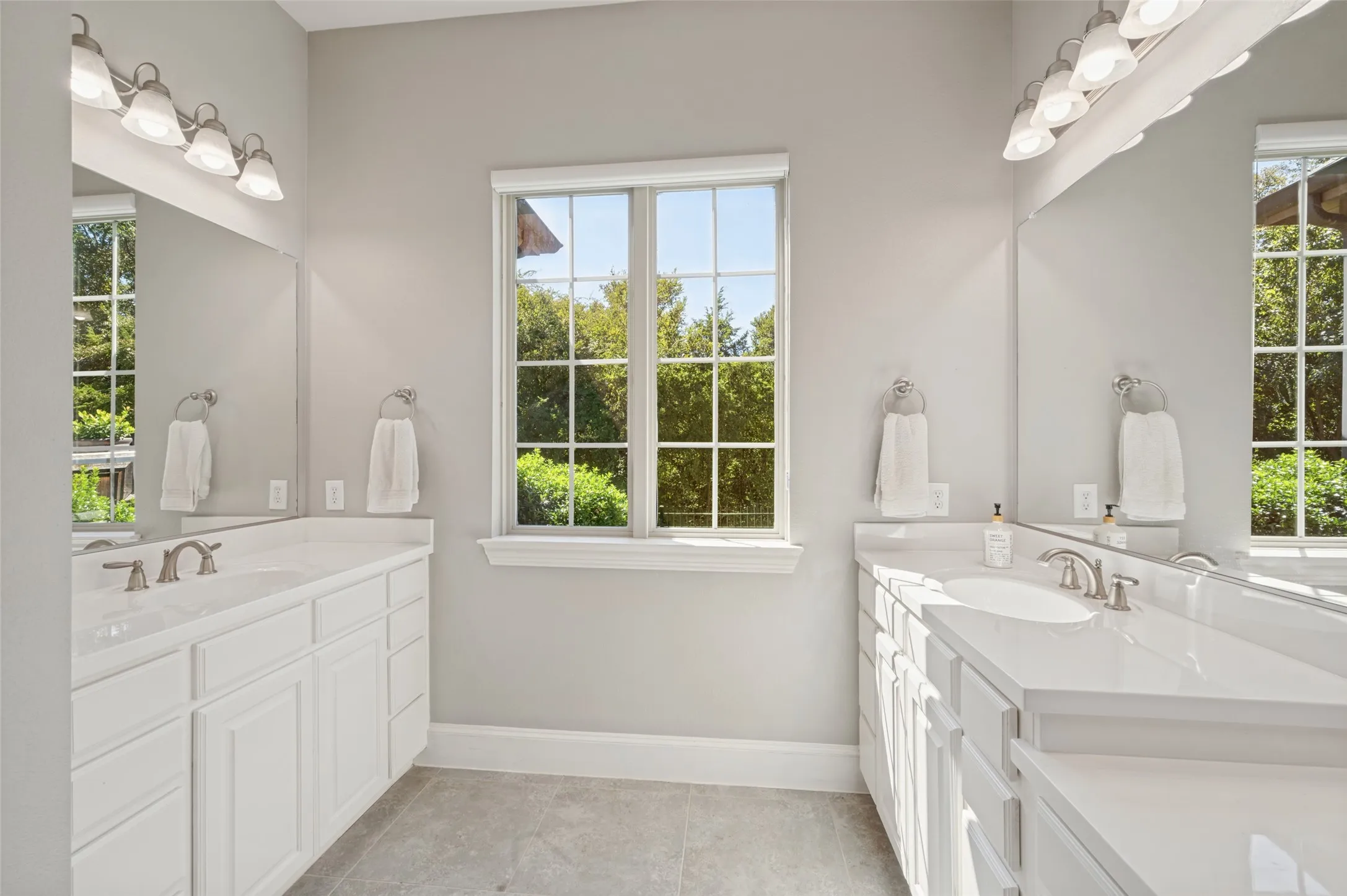 First floor primary suite with generous space and an ensuite bath featuring separate vanities, a soaking tub and separate shower.
