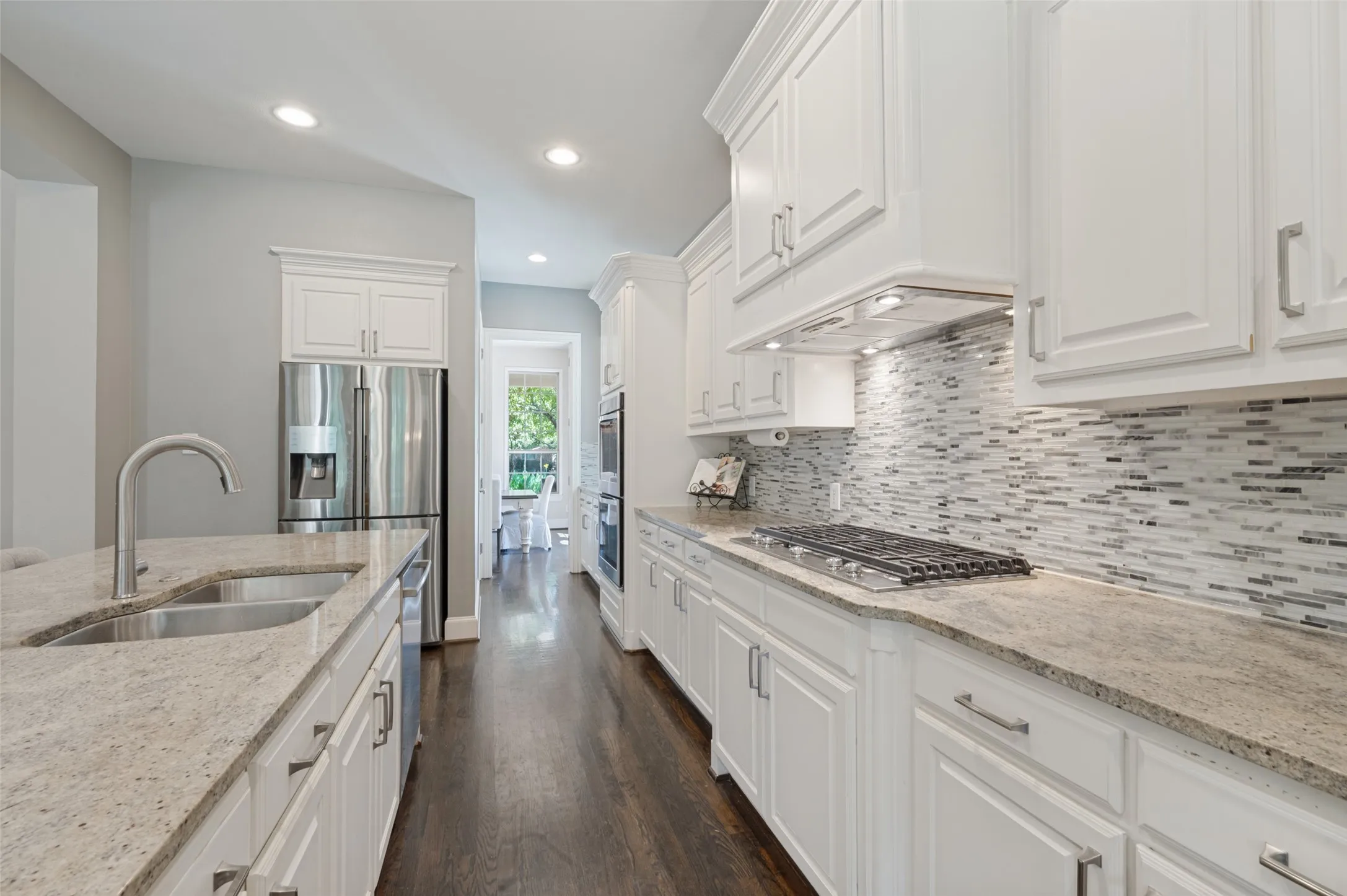 Chef’s kitchen with a large center island, five burner gas cooktop, double ovens, range hood and butler’s pantry.