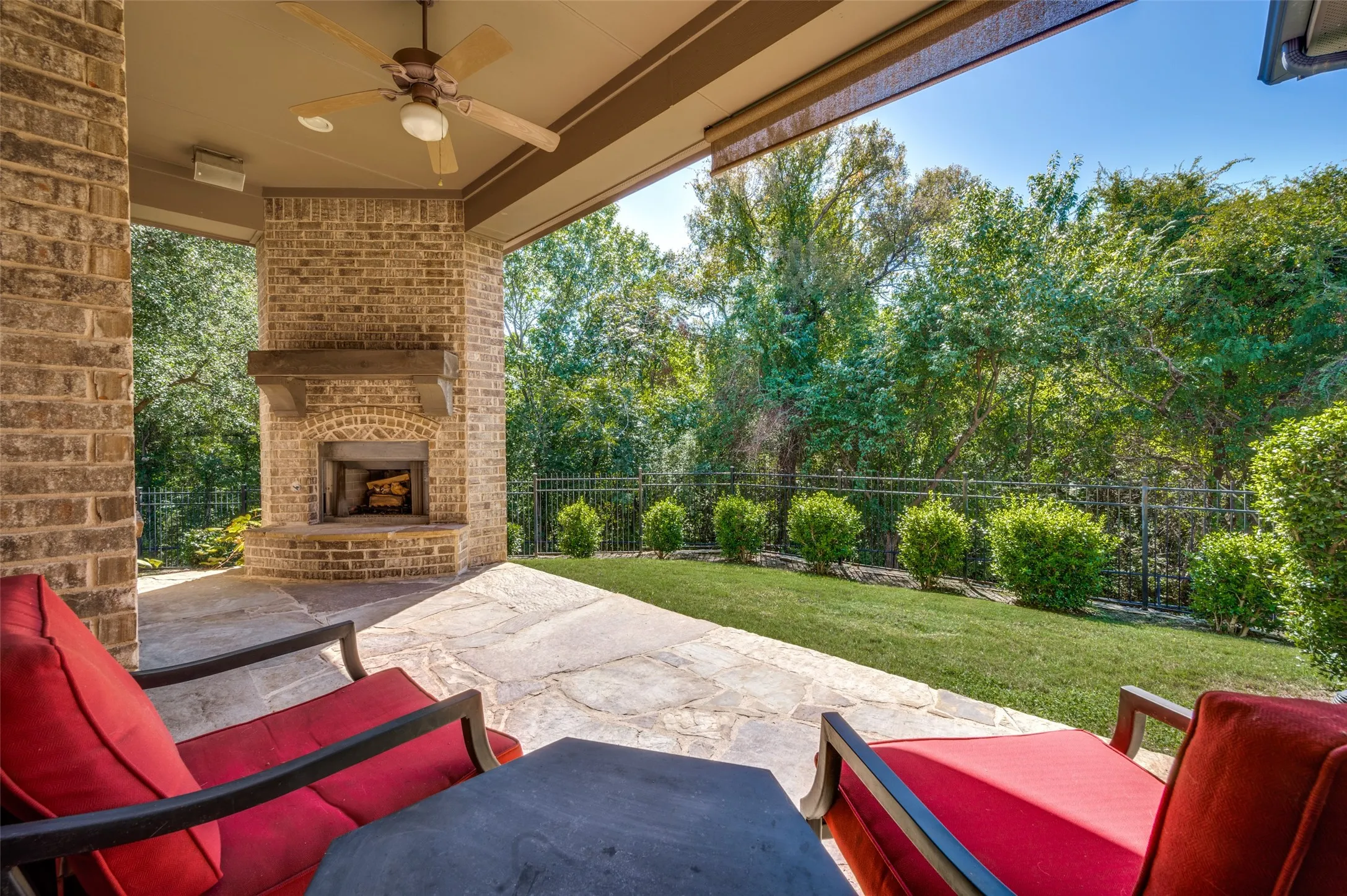 Covered patio with a wood-burning fireplace overlooking the greenbelt and spacious backyard.