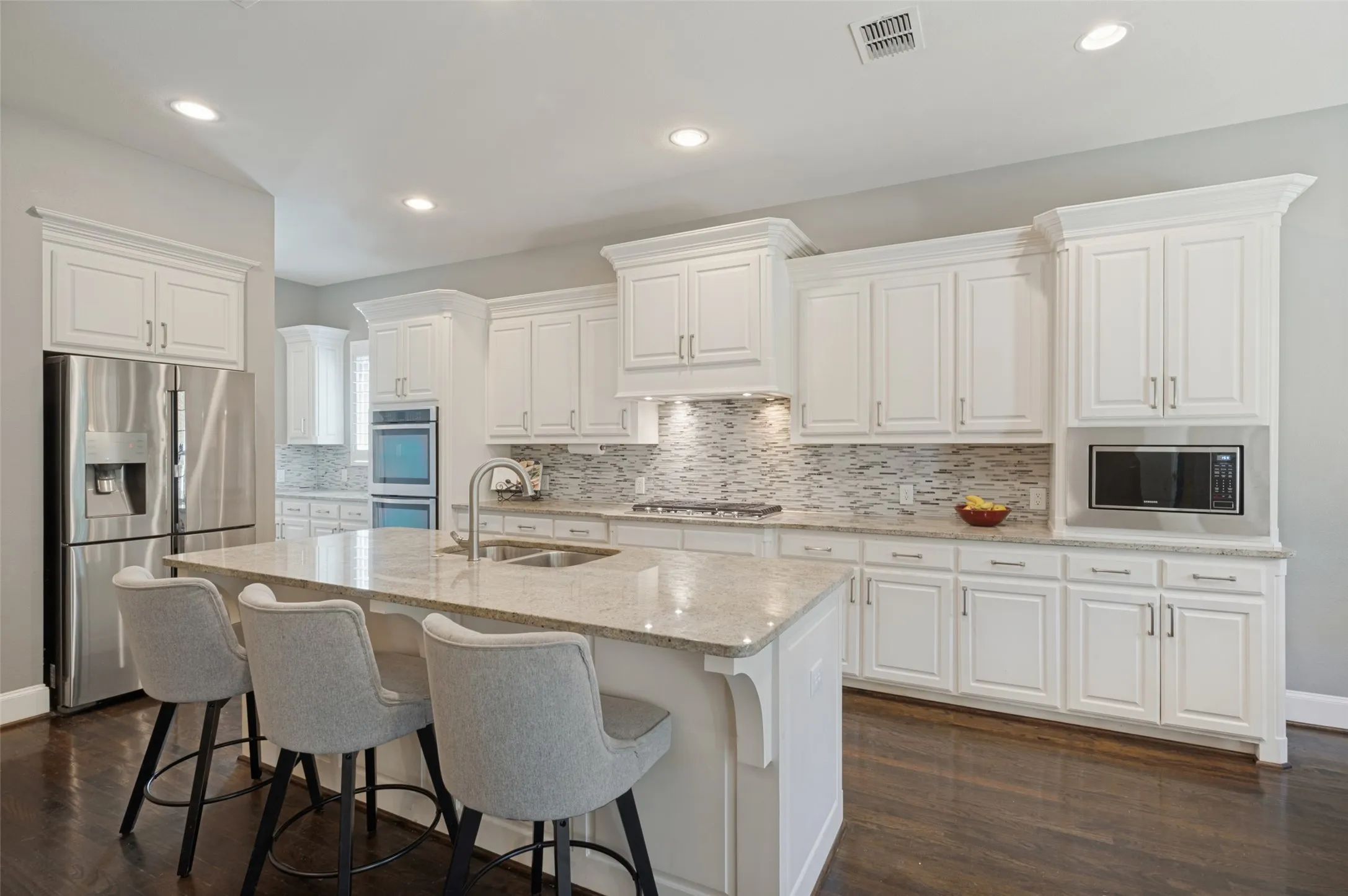 Chef’s kitchen with a large center island, five burner gas cooktop, double ovens, range hood and butler’s pantry.