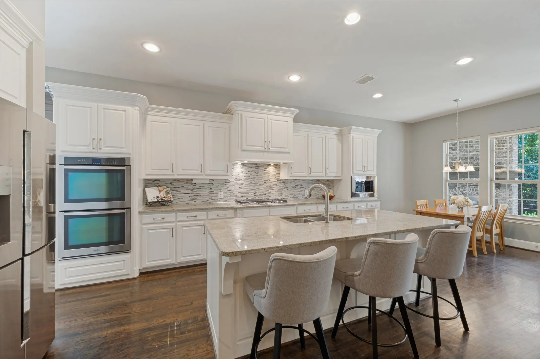 Chef’s kitchen with a large center island, five burner gas cooktop, double ovens, range hood and butler’s pantry.