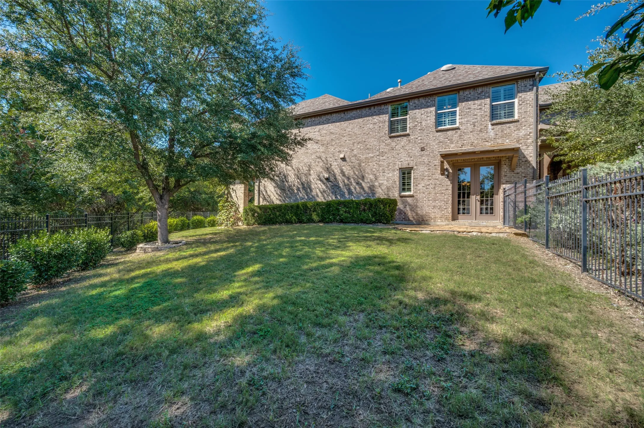 Covered patio with a wood burning fireplace overlooking the greenbelt and spacious backyard.