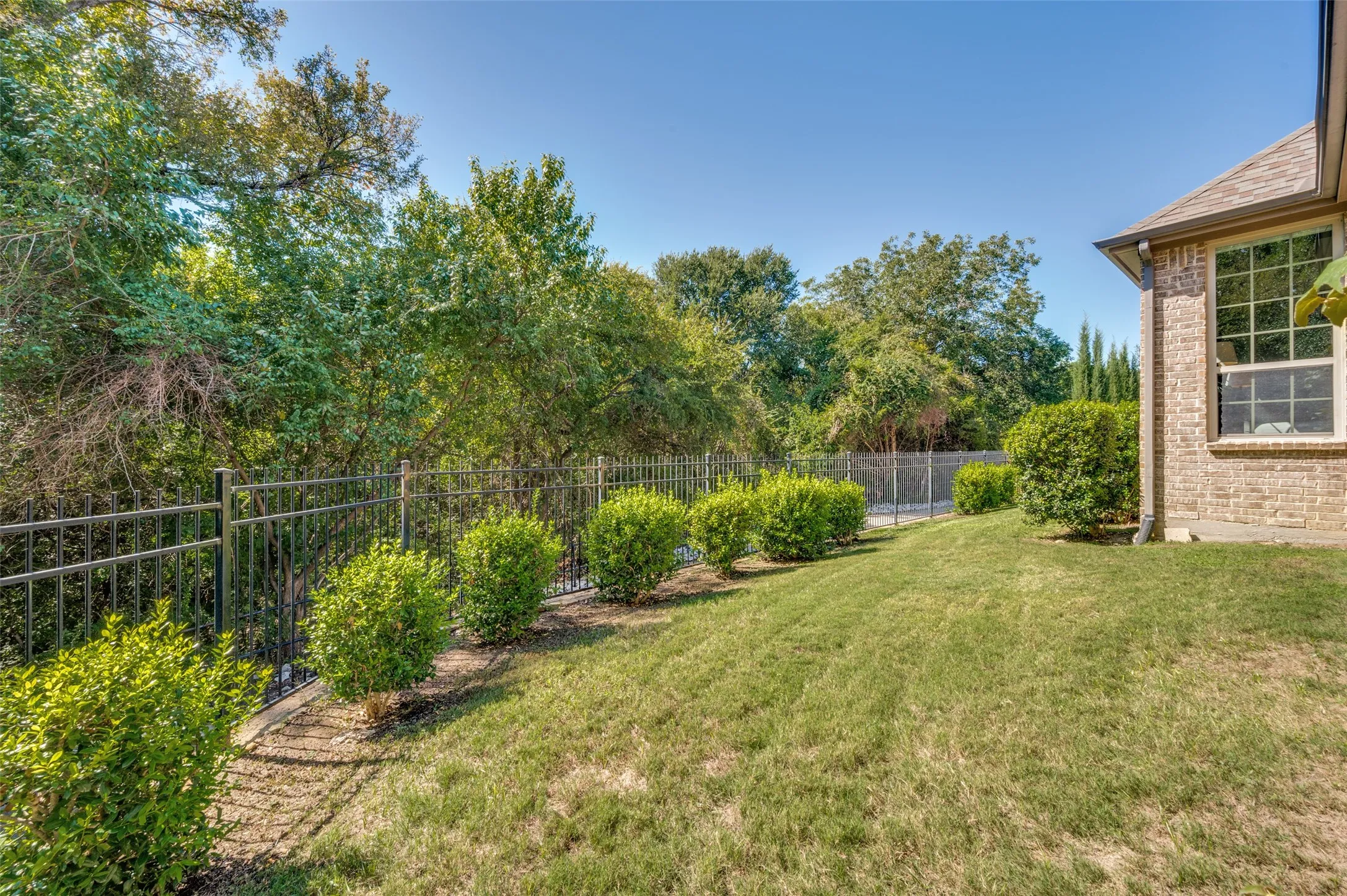 Covered patio with a wood burning fireplace overlooking the greenbelt and spacious backyard.