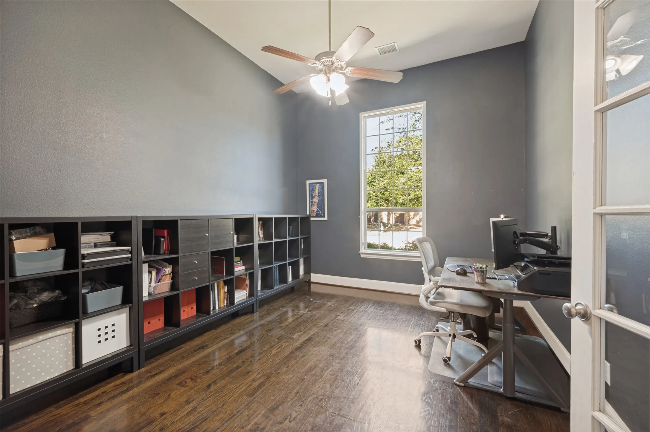 Executive study with French doors and extensive wood flooring.